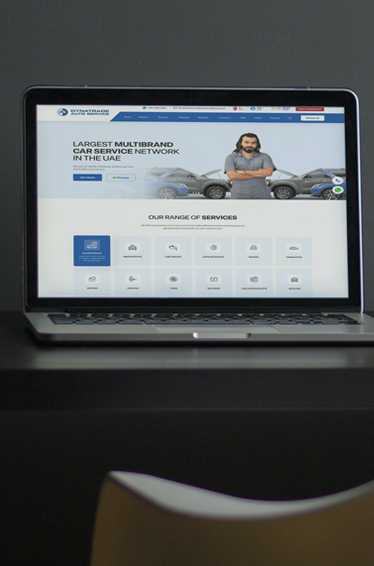 A laptop on a desk displaying an automobile website design, showcasing a modern and user-friendly interface.